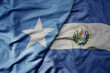 big waving national colorful flag of el salvador and national flag of somalia .