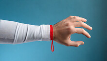 male hand with red thread