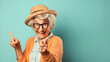 Funny old senior woman or grandma wearing a tropical shirt, smiling and pointing her finger at the camera. Aged female with glasses, funny elderly retired pensioner