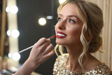 Fototapeta  - Makeup artist working with beautiful woman in cosmetic salon, closeup