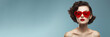 © Olga - Wide banner with woman wearing big heart shaped sunglasses portrait, retro style make up, blue background