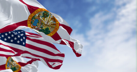 Wall Mural - Flags of Florida and United States waving in the wind on a clear day