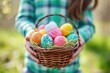 Child holding a basket of Colorful Easter eggs. Kids hunt for eggs outdoors concept.