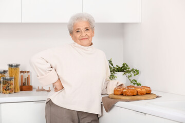 Poster - Senior woman with tasty buns in kitchen