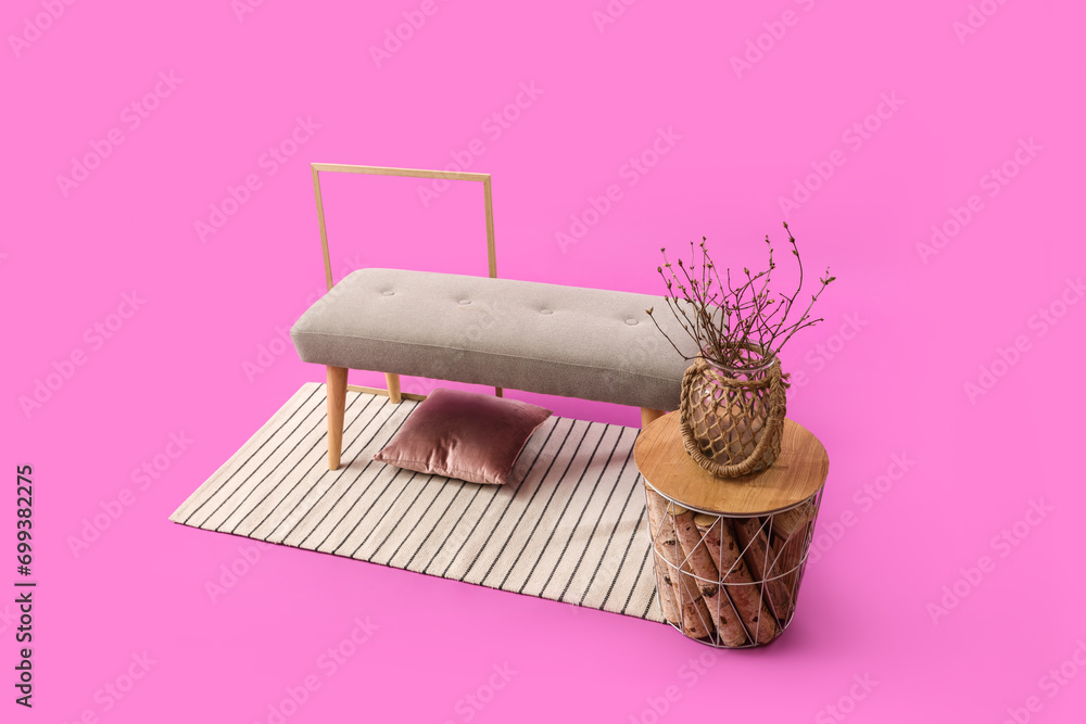 Grey bench with coffee table and rug on pink background