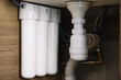 Home water filtration plant close-up. Small water filters under the sink in the kitchen