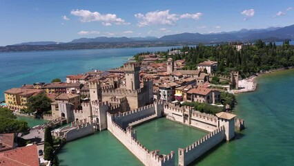 Wall Mural - The historical part of the city of Sirmione on Lake Garda in Italy, slow motion shot by drone. Sirmione high altitude view. Scaliger Castle of the city of Sirmione 4K video on drone.