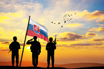 Silhouettes of soldiers with the Slovakia flag stand against the background of a sunset or sunrise. Concept of national holidays. Commemoration Day.