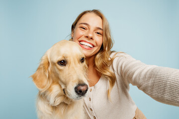 Wall Mural - Close up young owner woman with her best friend retriever dog wearing casual clothes do selfie shot pov mobile cell phone isolated on plain pastel light blue background. Take care about pet concept.