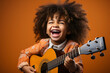 Joyful child playing guitar isolated on flat orange background with copy space. Creative banner for children's music school