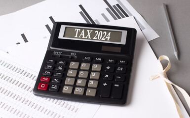 Wall Mural - TAX 2024 text on calculator with chart on grey background