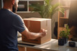 © Virtual Art Studio - Man in office preparing a cardboard box for shipment with sunlight streaming in.