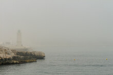 Lighthouse In The Morning Mist. Yellow Buoys In The Water Of The Mediterranean Sea. Cassis, Bouches-du-Rhône, France.