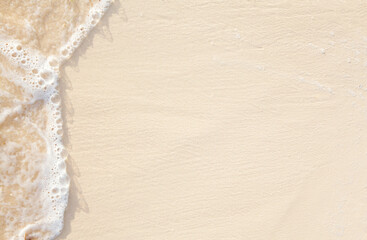 Wall Mural - beautiful abstract sandy beach from above with edge of water and sand in the sun, clean empty natural background with copy space for your advertising and product presentation