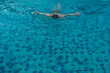 © Dontree - Top view of young man swimming front crawl in blue water