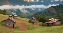 Rustic Wooden Building With Metal Roofs On A Grassy Hill, Picturesque Landscape Of A Rural Area, Dirt Path, Misty Mountains