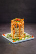 Cheddar French fries tower on grey background.