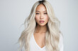 © Nikki AI - Beauty Portrait of Platinum Blond Asian Girl With Clean Healthy Skin and Long Hair on Light Grey Background