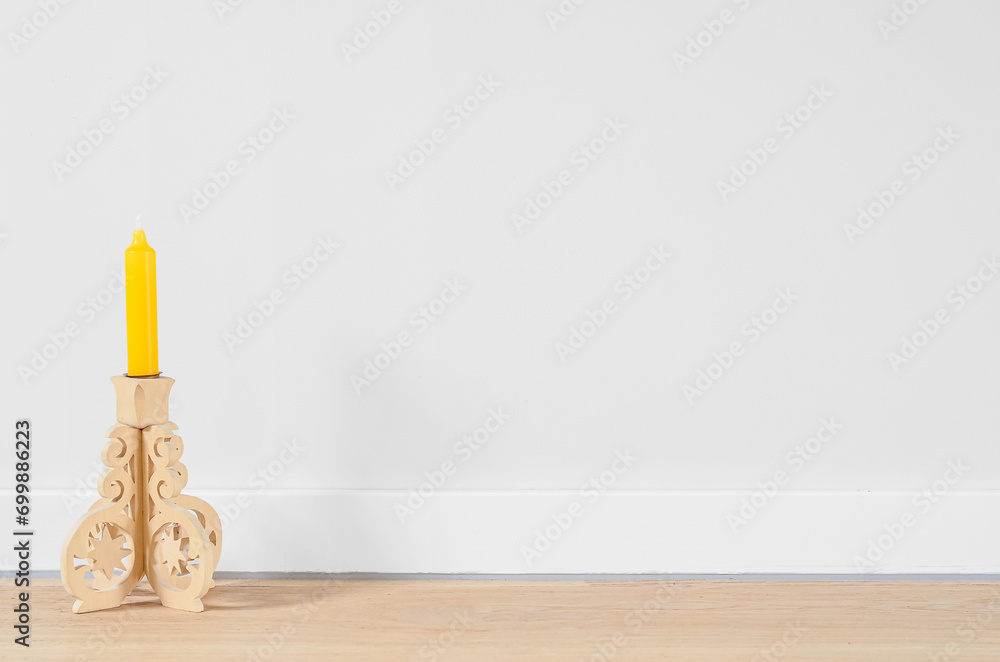 Vintage candle holder near light wall