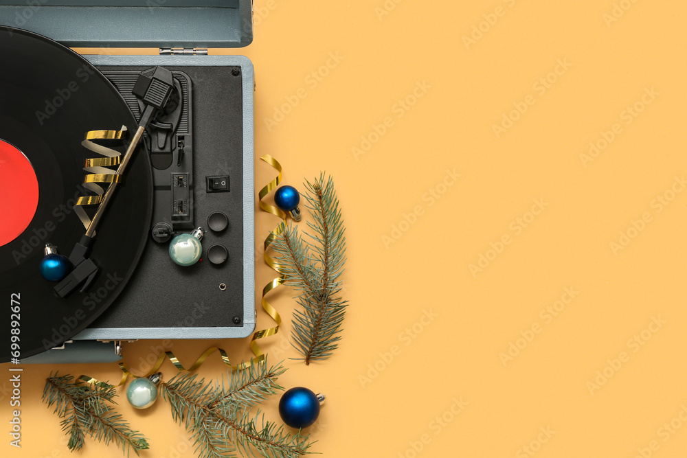 Vintage vinyl record player with Christmas decorations on beige background
