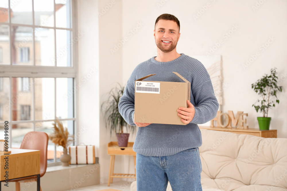 Young man with open parcel box at home