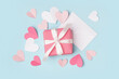 © Pixel-Shot - Envelope with gift box and paper hearts on blue background. Valentine's Day celebration