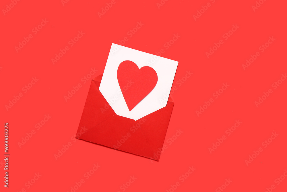 Composition with envelope, card and paper heart on red background. Valentine's Day celebration