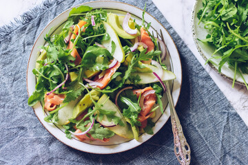 Wall Mural - Healthy salad with arugula, smoked salmon, pear, avocado and red onion