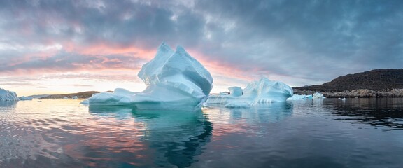 Wall Mural - Melting icebergs by the coast of Greenland, on a beautiful summer day - Melting of a iceberg and pouring water into the sea. Global warming
Arctic nature landscape, Summer day