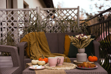 Canvas Print - Rest on terrace with rattan furniture. Drink, dessert and autumn decor on table