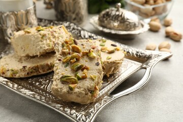Wall Mural - Tasty pistachio halva on light grey table, closeup