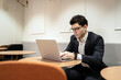 © muse studio - A young manager uses a computer in a new office, is busy with work, correspondence with a client online in a chat.
