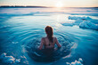 Woman in icy water during winter, polar bear plunge into a hole in the ice. Winter bathing. Shallow field of view.
