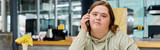 Fototapeta  - young woman with mental disability talking on mobile phone in modern and cozy cafe, banner