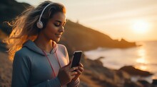 Young woman using smartphone and headphones to exercise on the beach
