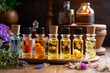 © Madeleine Steinbach - Various bottles of aromatherapy essential oils on a table with plants and herbs