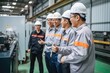 © sambath - Several chinese engineers wearing gray uniform and safety helmet standing in line with thumbs up with background of diesel generators factory workshop. a clean,