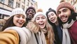 Happy friends group wearing winter clothes taking selfie walking on city street , Cheerful young people hanging outside enjoying winter holidays , Friendship with guys and girls laughing loud