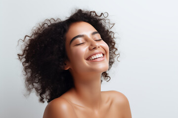 Canvas Print - Beautiful happy Latin American woman takes care of her skin, posing over grey background