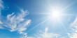 © alinamd - Cumulus clouds and bright sun in the sky. Wide photo.