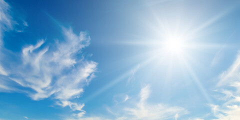 cumulus clouds and bright sun in the sky. wide photo.