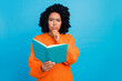 © deagreez - Photo portrait of lovely young lady thoughtful minded reading dressed stylish knitted orange garment isolated on blue color background