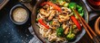 Photo of Chinese vegetable noodles with chicken, mushrooms, broccoli, pepper, lettuce, asparagus, and sesame seeds.