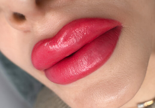 permanent makeup on the lips of a young woman of a delicate peach shade close-up, a girl after a cos