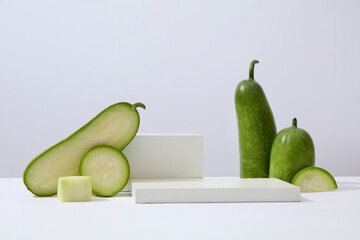 Wall Mural - Over white background, geometric shaped podiums displayed with winter melon slices. Research indicates that Winter melon (Benincasa hispida) is rich in polyphenols