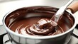 A pot of melted chocolate with a spoon for easy dipping. Perfect for desserts and baking recipes