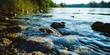 A scenic view of a river with rocks and grass in the water. Suitable for nature-themed designs and outdoor publications