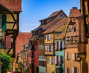 Canvas Print - Ornate traditional half timbered houses with blooming flowers in a popular village on the Alsatian Wine Route, in Riquewihr, France