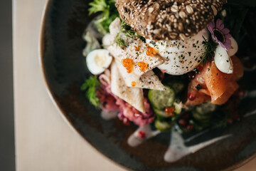 Wall Mural - Culinary lunch bread with salmon, egg, burrata, salad on a plate