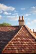A scene capturing the completion of a roof with a traditional brick tile ridge cap.